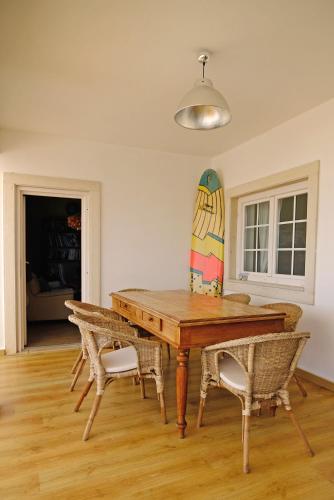 a dining room with a table and chairs and a surfboard at FreeSurfCamp & Hostel in Peniche