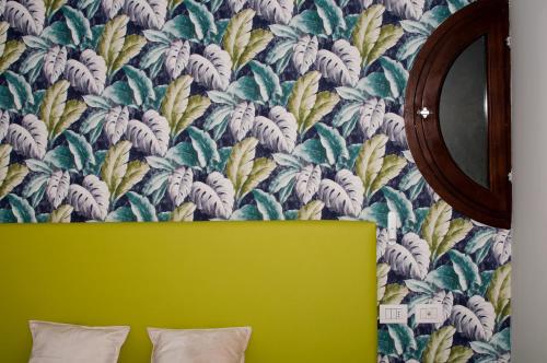 a bedroom with a green bed and a floral wallpaper at Hotel Ca' di Gali in Sasso Marconi
