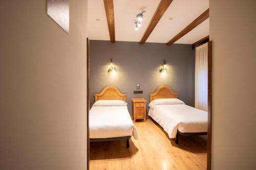 a bedroom with two beds and a mirror at Alda Casco Antiguo in León