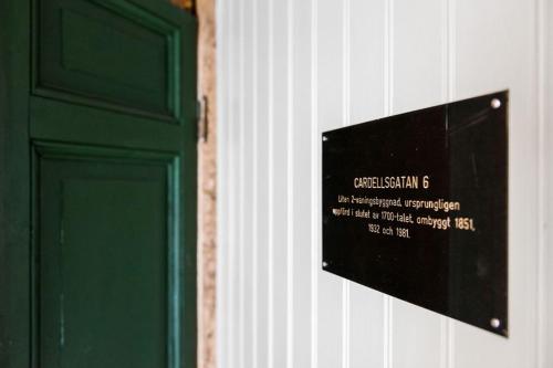 a sign on a wall next to a green door at Kristianstad Guest House in Kristianstad