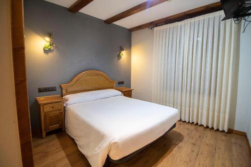 a bedroom with a white bed and a window at Alda Casco Antiguo in León