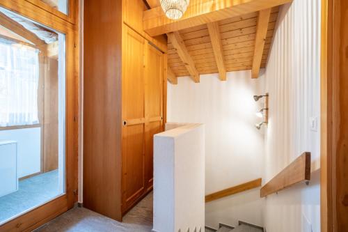 un pasillo de una casa con techos de madera en Casa Darschalè 11, en Laax