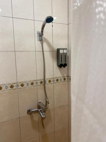 a shower with a shower head in a bathroom at 暮川旅宿 走路可達小港機場附兩個停車位 in Kaohsiung