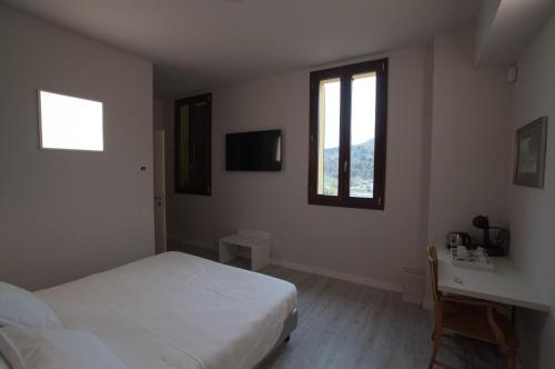 a bedroom with a bed and a desk and window at Hotel Ca' di Gali in Sasso Marconi