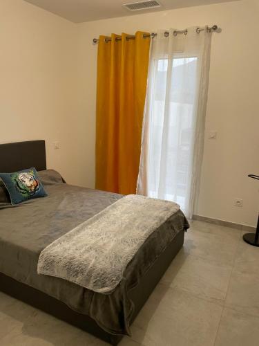 Un dormitorio con una cama y una ventana con cortinas. en Villa Jean Baptiste, en Patrimonio