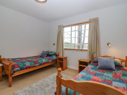 a bedroom with two beds and a window at The Bungalow in Elgin