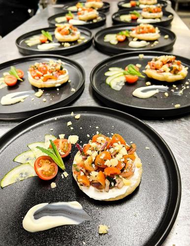 a bunch of pizzas on black plates on a table at Hotell Tjamstan Malå in Malå
