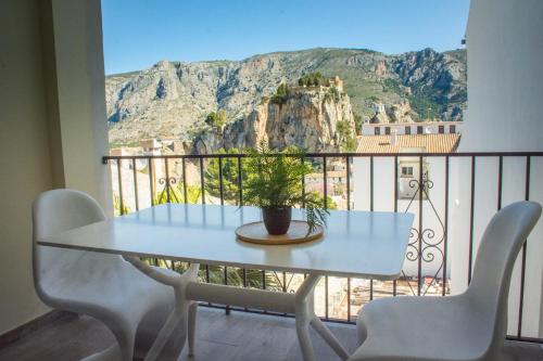 un tavolo e sedie su un balcone con vista di El Tossal a El Castell de Guadalest