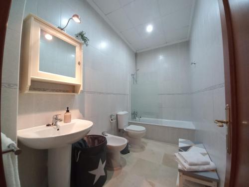a white bathroom with a sink and a toilet at LASPALOMAS18 in Sanlúcar de Barrameda