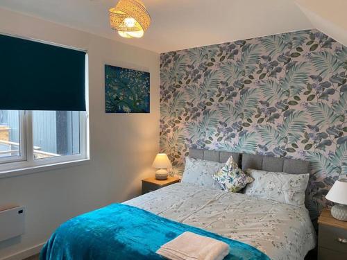 a bedroom with a bed with a blue comforter at Central Newly built 2 Bed DUPLEX Penthouse with FREE On-site Gated Parking, Lift access, Self Check-in, SUPER Fast WIFI, TWO Cathedral view Terraces & Sleeps 6 in Peterborough