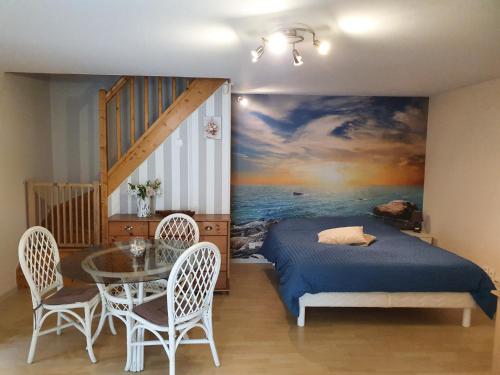 1 dormitorio con 1 cama y 1 mesa con sillas en Le relais de la cure en Saint-Juire-Champgillon
