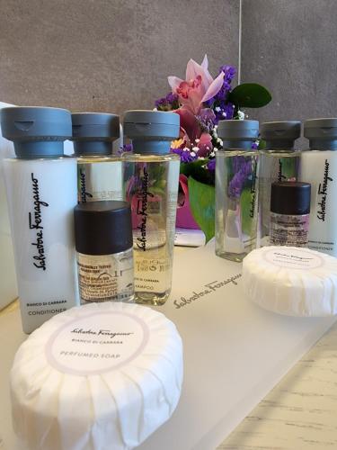 a table with several bottles of moisturizers and flowers at B&B Seataly by W Signature Experiences in Civitavecchia
