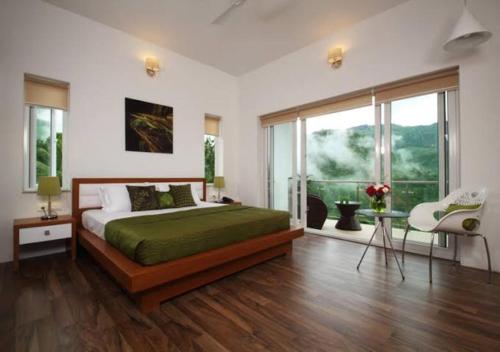 a bedroom with a bed and a large window at SWISS COUNTY in Idukki