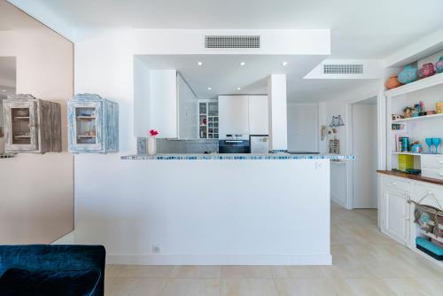 une cuisine avec des placards blancs et un grand îlot dans l'établissement Wdf sea-view one bedroom heart of Cannes, à Cannes