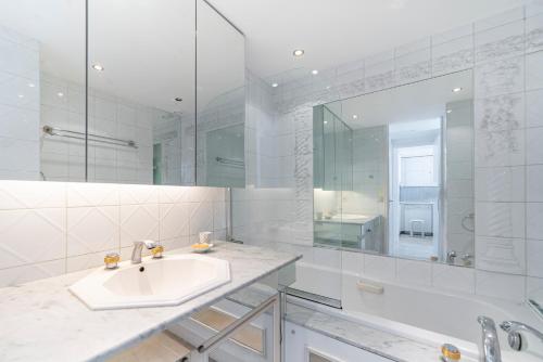 une salle de bain blanche avec un lavabo et un miroir dans l'établissement Wdf sea-view one bedroom heart of Cannes, à Cannes