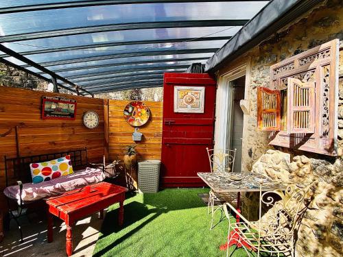 a patio with a table and a red door at Studio le moulin de Pascale in Espelette