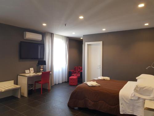 a hotel room with a bed and a desk and a window at Hotel Europa Art Caserta in Caserta