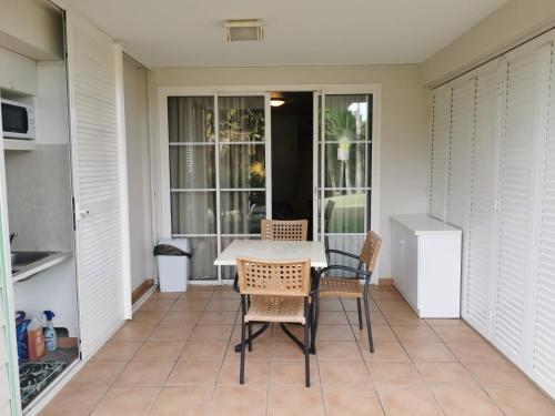 eine Terrasse mit einem Tisch und Stühlen auf einer Veranda in der Unterkunft Tropik-Appart - Studio in Sainte-Luce