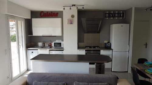 a kitchen with white appliances and a black counter top at Très beau 3 pièces spacieux lumineux et climatisé in Nice