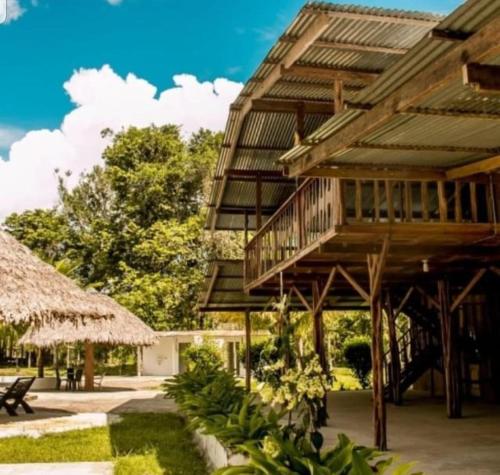 un edificio de madera con terraza y patio en Hotel Karupa Amazonas en Leticia