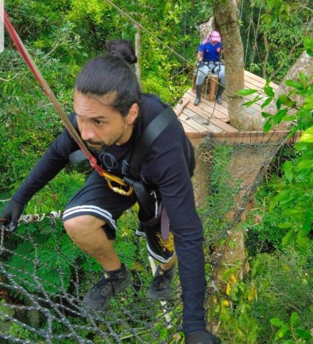 a man on a rope bridge in the woods at Hotel Karupa Amazonas in Leticia