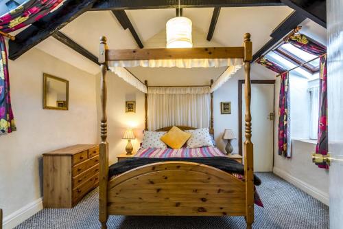 a bedroom with a wooden bed in a room at The Loft - 1 Bedroom Apartment - Saint Florence, Tenby in Saint Florence