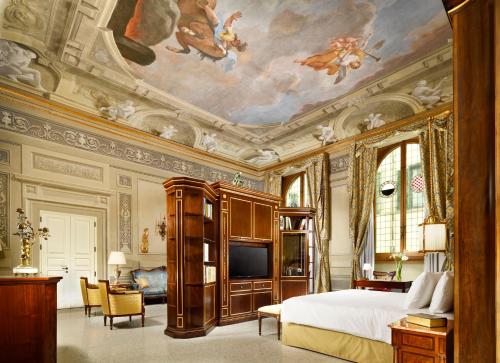 una camera da letto con un letto e un dipinto sul soffitto di Palazzo Portinari Salviati Residenza D'Epoca a Firenze