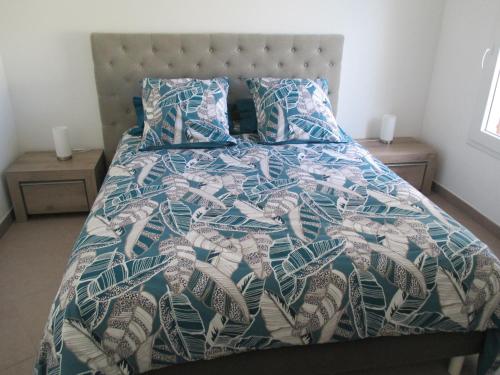 - un lit avec une couette et des oreillers bleus et blancs dans l'établissement Sanary Paradise, à Sanary-sur-Mer