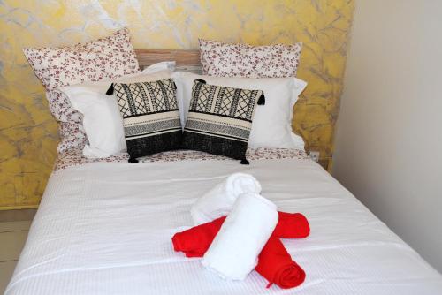 Una cama con un animal de peluche rojo. en Studio avec vue sur la ville balcon et wifi a Baie Mahault, en Baie-Mahault