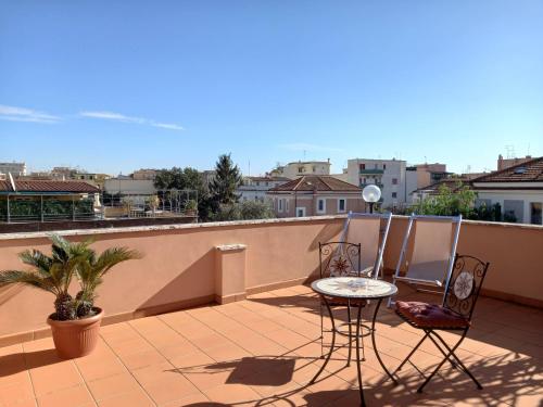 patio z 2 krzesłami i stołem na balkonie w obiekcie L'Oasi al Pigneto - Guest house w Rzymie