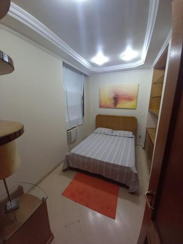 a small bedroom with a bed and a red rug at Apartamento Assu in Rio de Janeiro