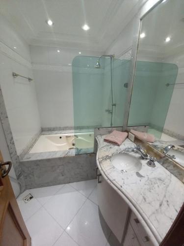 a bathroom with a glass shower and a sink at Apartamento Assu in Rio de Janeiro