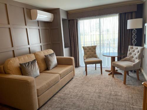 a living room with a couch and a table at Park Farm Hotel in Norwich