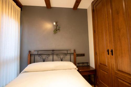 a bedroom with a bed and a wooden door at Alda Casco Antiguo in León