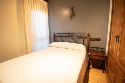 a small bedroom with a bed and a window at Alda Casco Antiguo in León