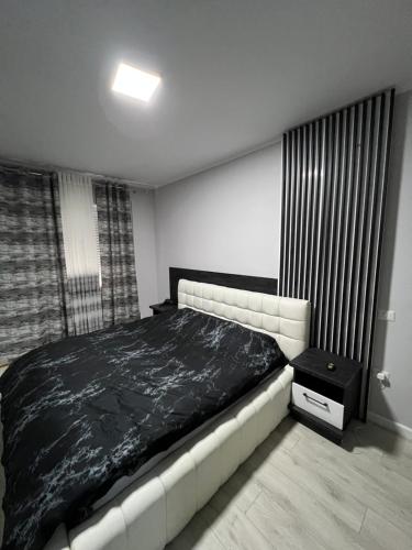 een slaapkamer met een groot bed en een zwarte deken bij 090 Area in Tirana
