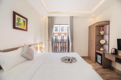 a bedroom with a large white bed and a television at Green bay hotel Ha Long in Ha Long