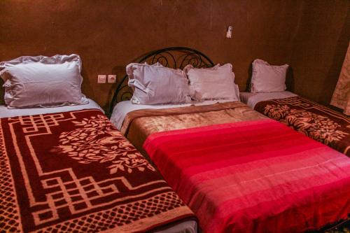 two beds sitting next to each other in a room at Kasbah Maison D’hôte Lalla Zahra in Aït Baha
