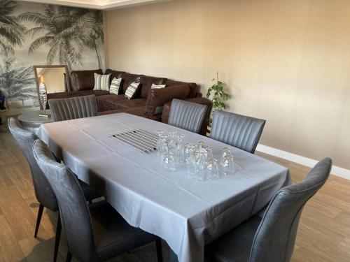 - une salle à manger avec une table, des chaises et un canapé dans l'établissement Fécamp, Etretat, Yport, joli appartement tout près de la plage et de la gare contactez-nous au zéro six soixante dix huit soixante treize trente six quatre vingt onze, à Fécamp