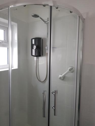 a shower with a glass door in a bathroom at Seamore Guest House in Great Yarmouth