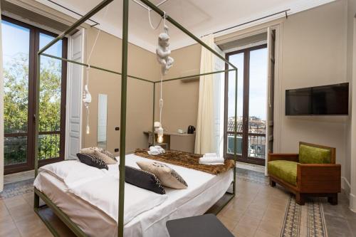 a bedroom with two beds and a tv and windows at 81 Suite and Breakfast in Catania