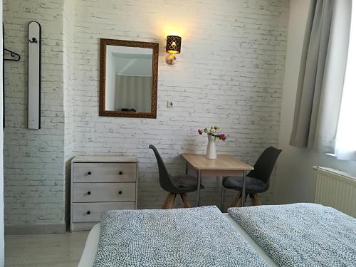 a bedroom with two beds and a table and a mirror at House LA Neuschwanstein Blick - Budget City Hotel in Füssen