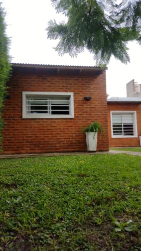 a brick house with a plant in a yard at Eljacaranda_ in Gualeguay