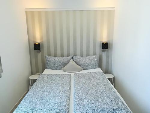 a bedroom with a large bed with two lamps at House LA Neuschwanstein Blick - Budget City Hotel in Füssen