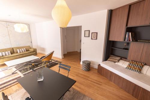 un salon avec une table et un canapé dans l'établissement L'Escale - Hypercentre - BED I HOME, à Angers