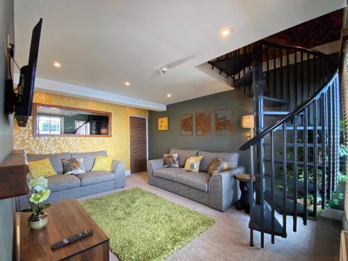 una sala de estar con 2 sofás y una escalera en Hambrook House Canterbury - NEW luxury guest house with ESPA Spa complex en Canterbury
