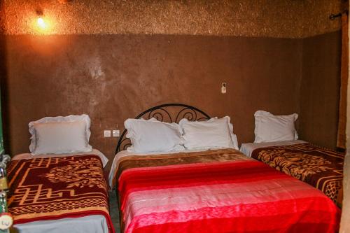 two beds in a hotel room at Kasbah Maison D’hôte Lalla Zahra in Aït Baha