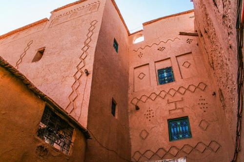 a building with drawings on the side of it at Kasbah Maison D’hôte Lalla Zahra in Aït Baha