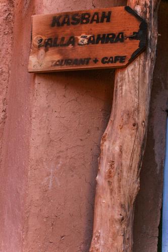 a wooden sign on the side of a building at Kasbah Maison D’hôte Lalla Zahra in Aït Baha