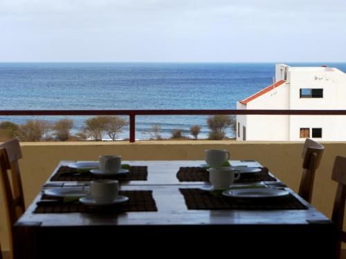 a table on a balcony with a view of the ocean at Casa Strela B&B Tarrafal in Tarrafal